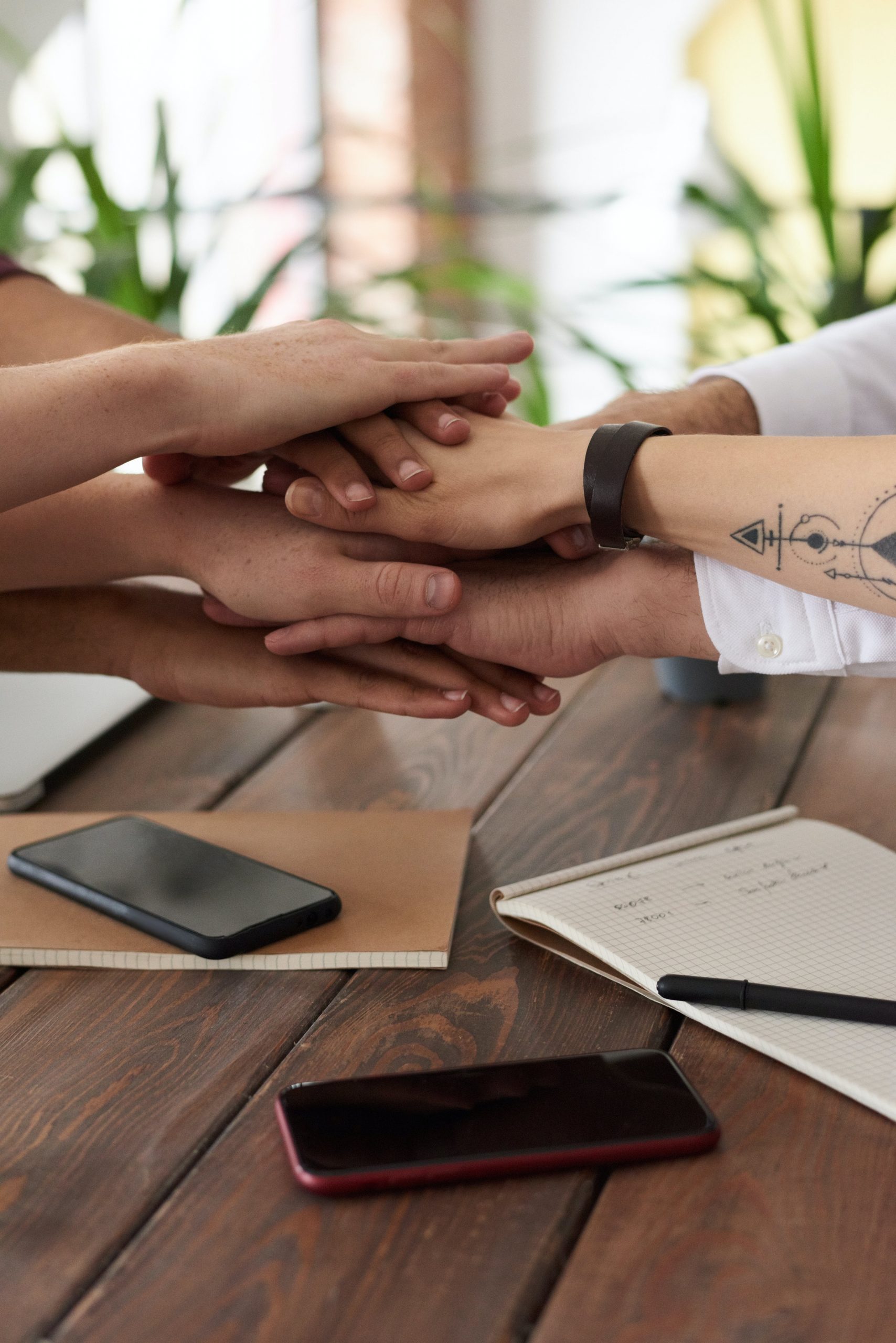 Zusammenarbeit: Hände eines Teams an einem gemeinsamen Tisch